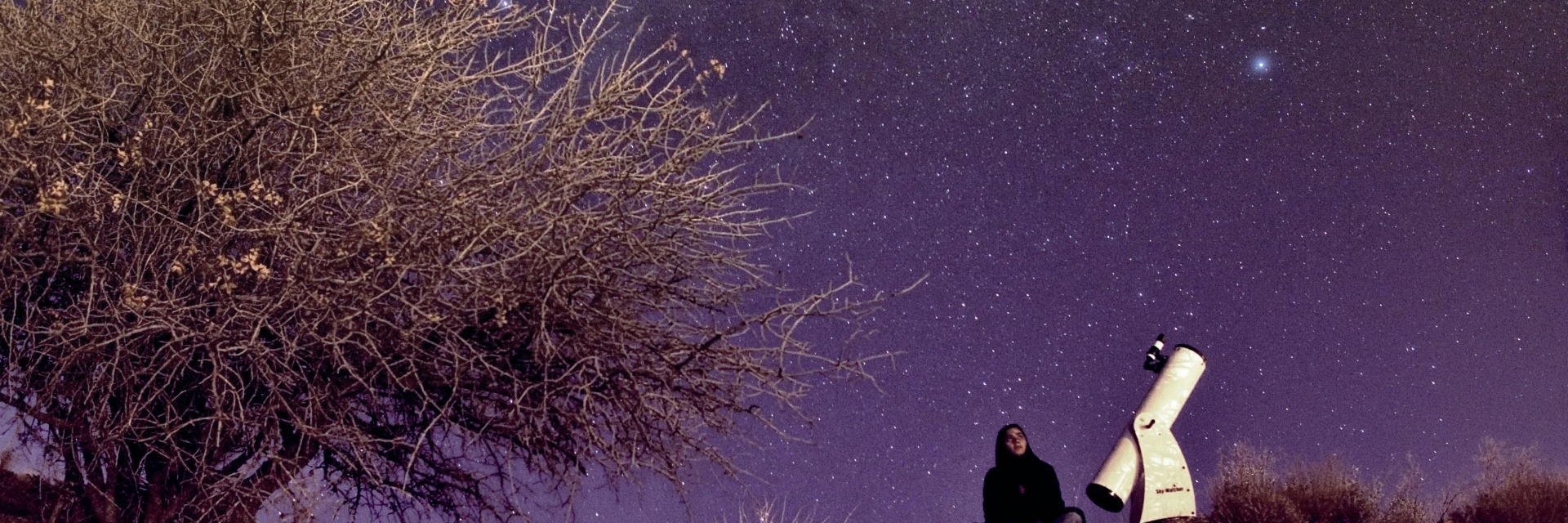 Woman with telescope looking up at the night sky. Still from the film Sapideh