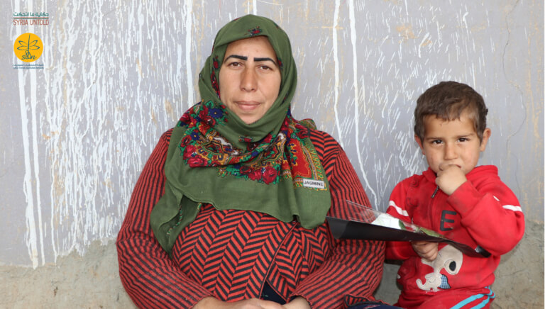 Hanaa al-Khalaf, 40, and her son Shadi, 3, in front of their home in Jin War, 7 March 2020. (Photo: Syria Untold and Syrian Female Journalists Network)