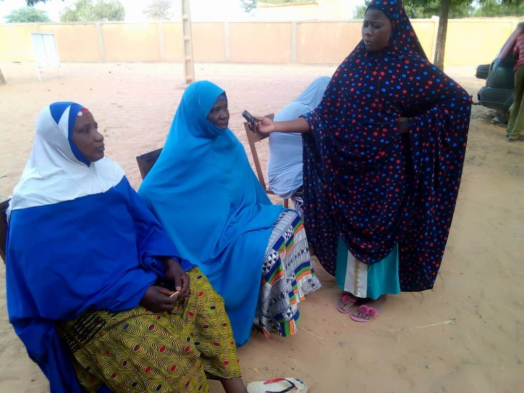 A female journalist is interviewing three women for the radio