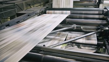 Printing newspapers Newspapers being printed in printing press.