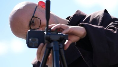 Rome Prepares For Pope's Funeral A member of the clergy prepares for a live broadcast with his mobile phone on a tripoad in Rome, Italy on 24 April, 2025. Photo by Jaap Arriens/NurPhoto via Getty Images.